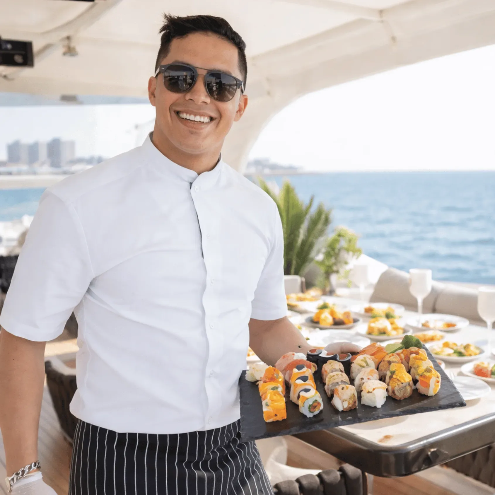 Chef presenting sushi platter on a luxury yacht deck in Miami