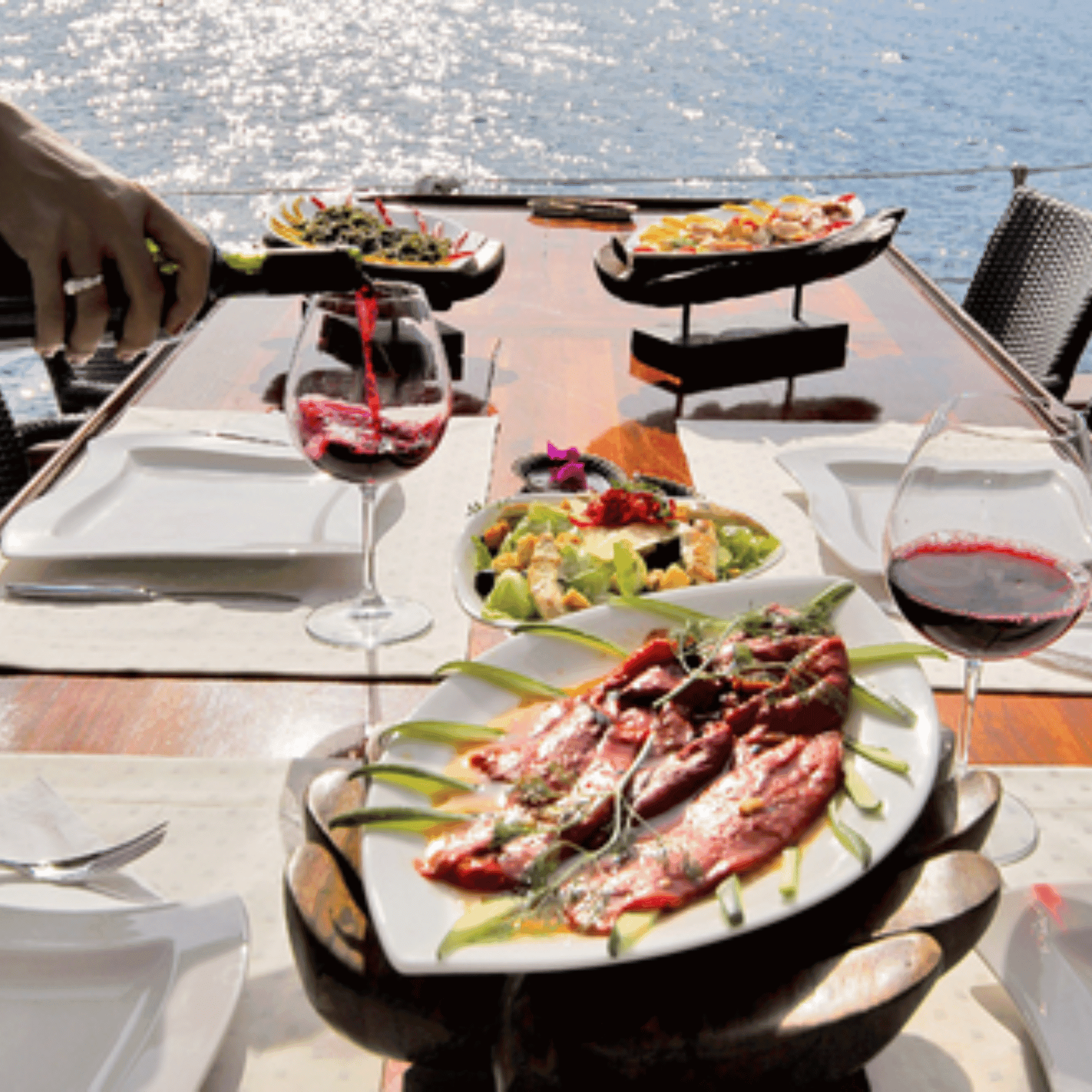 Gourmet dinner with wine on yacht deck