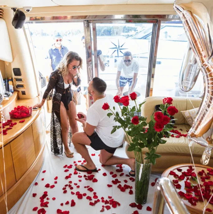 Surprise proposal inside decorated yacht cabin
