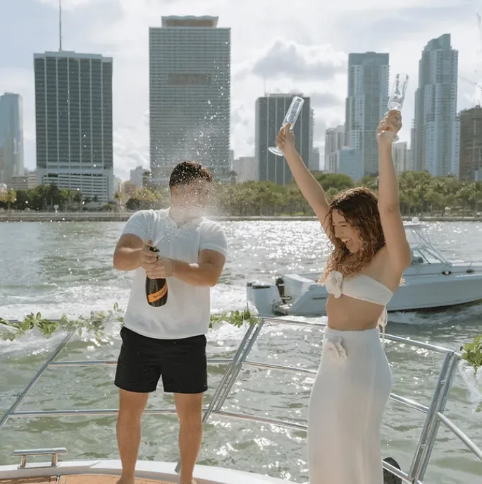 Couple celebrating proposal with champagne on yacht in Miami